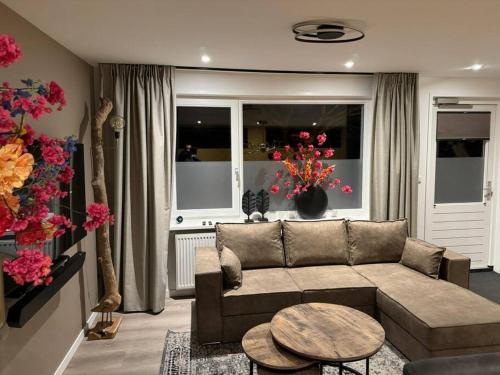 a living room with a couch and a table at Luxe woning Bubbles! Met airco en Parkeren op eigen grond in Castricum