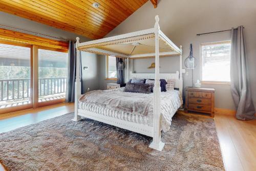 a bedroom with a white canopy bed and a rug at Le Chalet Bleu in Angel Fire