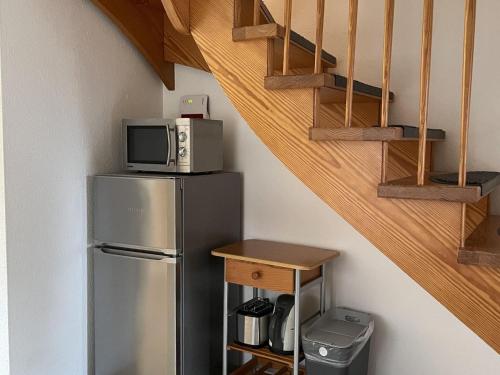 um micro-ondas em cima de um frigorífico ao lado de uma escada em Semi-detached house, Nessmersiel em Neßmersiel