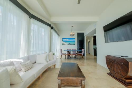 a living room with a white couch and a table at Diamante Beachfront Suites in San Pedro