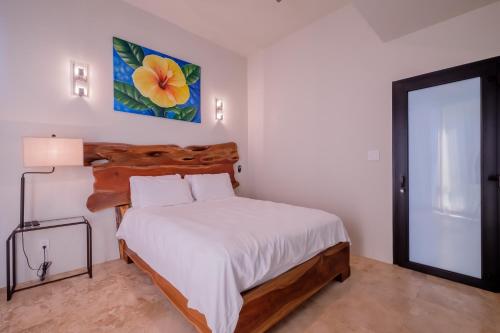 a bedroom with a bed and a painting on the wall at Diamante Beachfront Suites in San Pedro