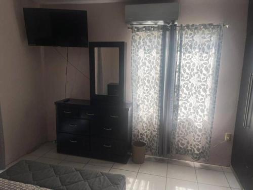 a bedroom with a dresser and a mirror and a dresser at Casa confortable cerca de playa in Ciudad Madero