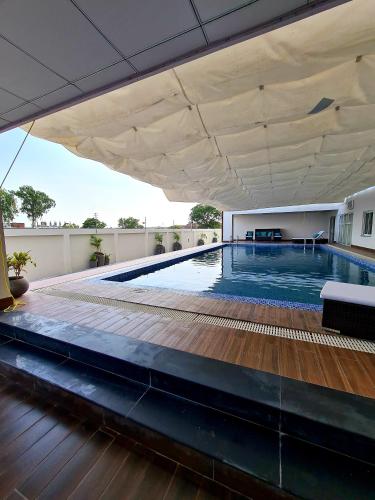 a large swimming pool with a wooden floor and a white ceiling at 1 Bed Modern Apartment, Pool, Gym, Cinema in Lahore