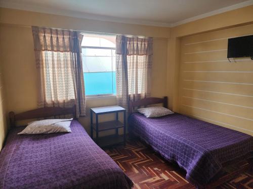 フリアカにあるHOSPEDAJE FESTEJOSのベッド2台と窓が備わる客室です。