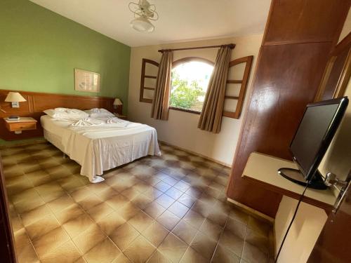 a bedroom with a bed and a television in it at Hotel Fazenda São Matheus in Serra Negra