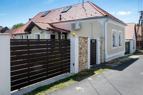 a house with a wooden fence in front of it at SáBa Vendégház in Tapolca