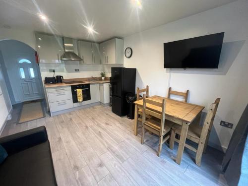 a kitchen with a wooden table and a kitchen with a black refrigerator at Mulberry Holiday Home in Great Yarmouth