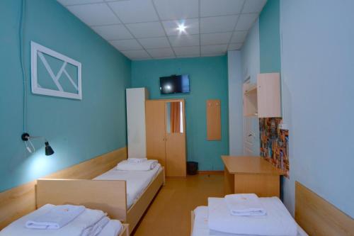 two beds in a room with blue walls at Podolski Hostel in Kyiv