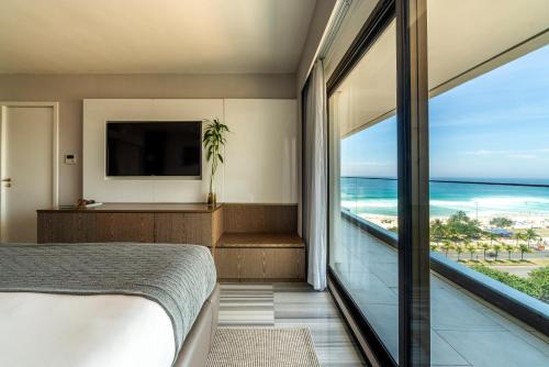 a bedroom with a view of the ocean at Lifestyle Laghetto Collection in Rio de Janeiro