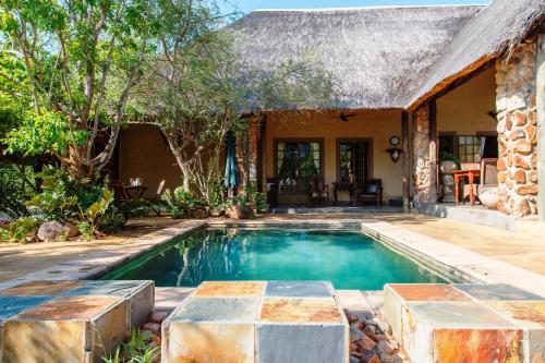 a swimming pool in front of a house at Shikwari Suites - Shikwari Nature Reserve in Hoedspruit