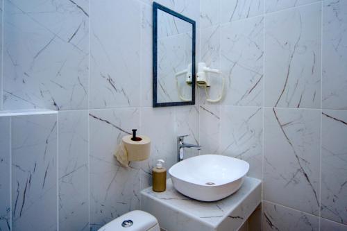 a white bathroom with a sink and a mirror at Podolski Hostel in Kyiv