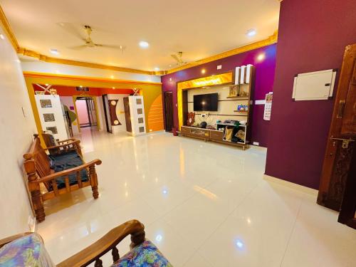 a living room with a white floor and purple walls at SS Home Stay Accomodation in Tiruvannāmalai