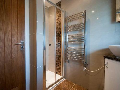 a shower with a glass door in a bathroom at Lavender Barn in Newquay