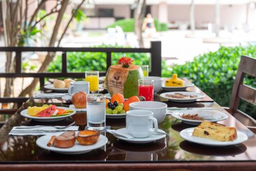 a table with plates of breakfast food on it at Vila Galé Fortaleza in Fortaleza