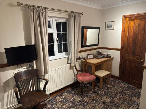 a room with a desk and a chair and a window at The George at Donyatt in Ilminster