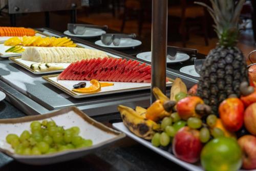 a buffet filled with different types of fruit on plates at Vila Galé Fortaleza in Fortaleza
