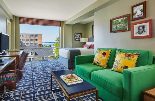 a hotel room with a green couch and a bed at Graduate by Hilton Madison in Madison