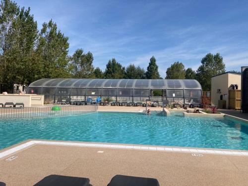 een groot zwembad met een gebouw op de achtergrond bij Mobil-home Ouistreham in Ouistreham