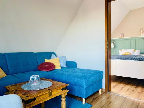 a living room with a blue couch and a table at Kajüthus Apartment 1 in Fehmarn