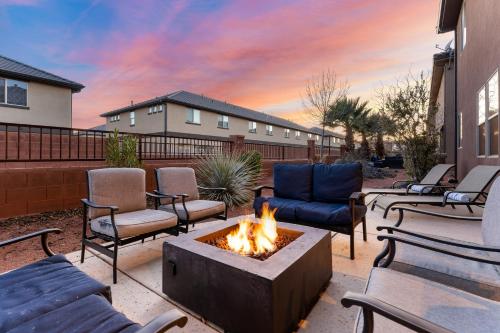 a patio with couches and a fire pit with a fire at Desert Solitaire #101 in Santa Clara