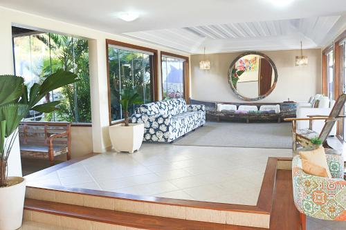 a living room with a couch and a mirror at Pousada La Dolce Vita in Búzios