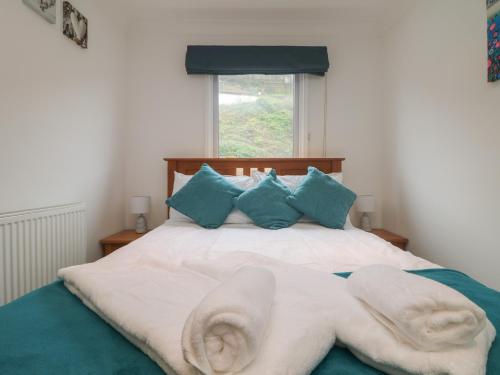a bedroom with a bed with towels on it at Ocean Blue in Porthtowan