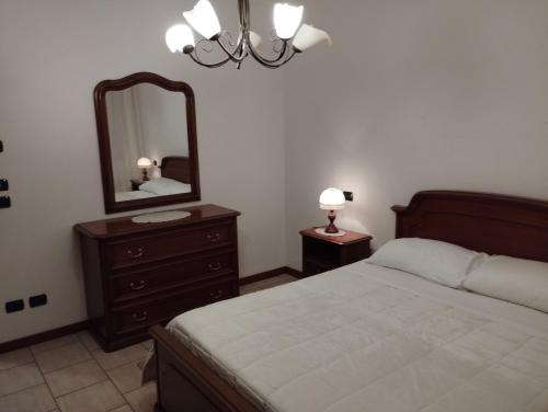 a bedroom with a bed and a dresser with a mirror at Fattoria I Canarini in Fossalta di Piave