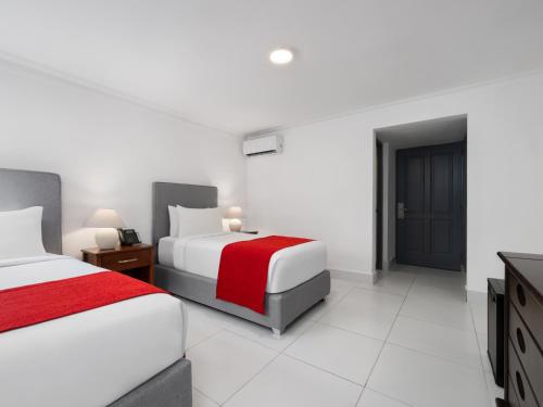 a hotel room with two beds and a television at Gran Hotel Europa Santo Domingo Trademark Collection by Wyndham in Santo Domingo