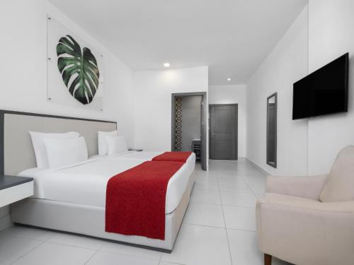a white bedroom with a bed and a couch at Gran Hotel Europa Santo Domingo Trademark Collection by Wyndham in Santo Domingo