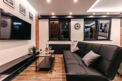 een woonkamer met een bank en een tafel bij Happy Night - Happy Apartamenty Mielec in Mielec