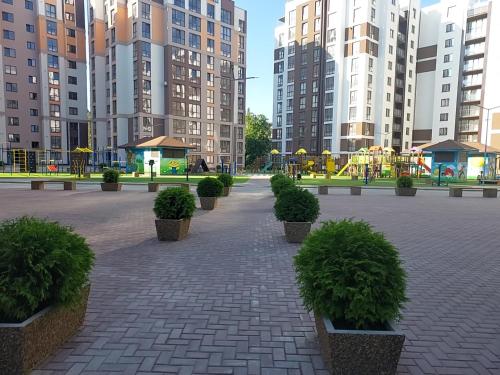 a park with benches and a playground and tall buildings at AIRPORT 24&24 CAR PARKING in Chişinău