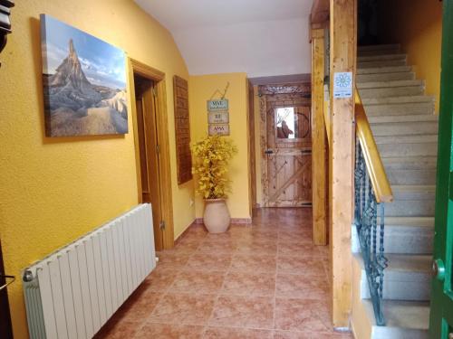 a hallway with yellow walls and stairs with a potted plant at EL PINAR DE BARDENA in Carcastillo