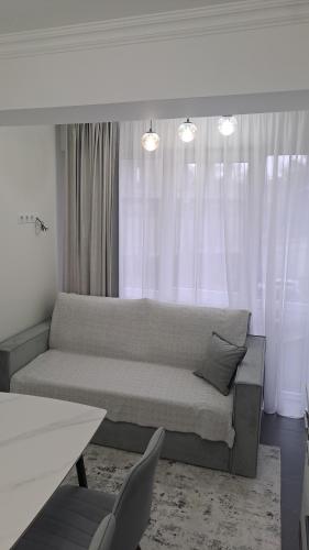 a living room with a couch in front of a window at AIRPORT 24&24 CAR PARKING in Chişinău
