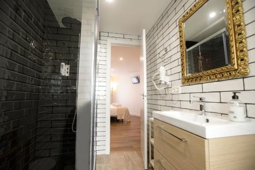 W łazience znajduje się umywalka i lustro. w obiekcie Apartamentos El balcón de la Trinidad Córdoba w Kordobie