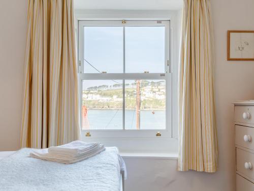 a bedroom with a window with a view of the ocean at 3 Bed in Polruan PC009 in Fowey