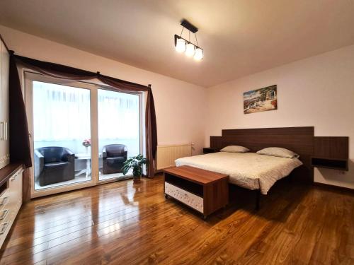ein Schlafzimmer mit einem Bett und einem großen Fenster in der Unterkunft Apartament Giulio in Sibiu