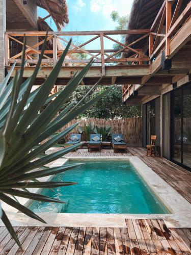 an indoor pool with a wooden deck and a house at Punta Tamarindo in Puerto Escondido