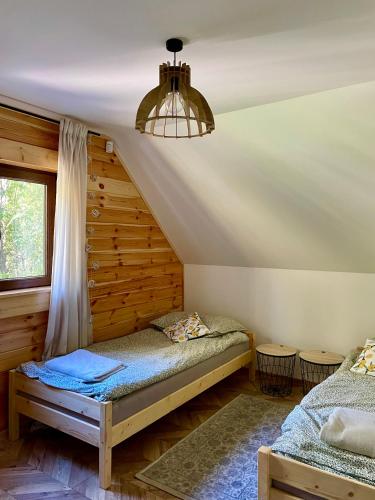 a bedroom with two beds and a chandelier at Zamojskie Bieszczady in Stary Zamość