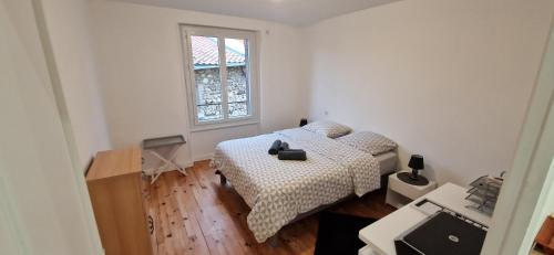 een kleine slaapkamer met een bed en een raam bij Le jusqu'à 7 in Le Cendre