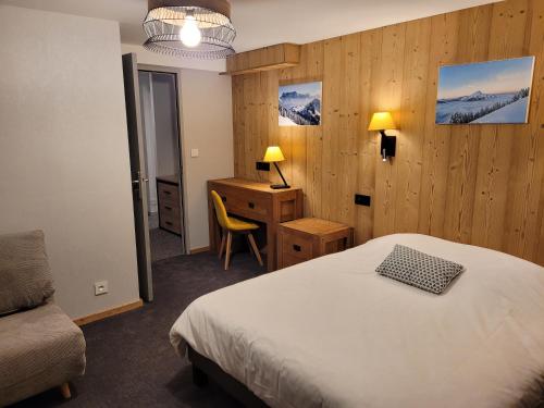 Schlafzimmer mit einem Bett, einem Schreibtisch und einem Stuhl in der Unterkunft Hôtel Belalp in Châtel