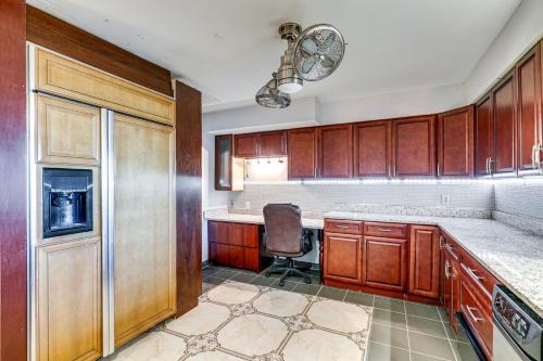 a kitchen with wooden cabinets and a chair in it at Canal-Front Ruskin Home with Private Hot Tub and Dock! in Ruskin