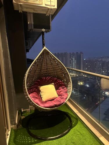una sedia sospesa con cuscino su un balcone di Yourhomely Studio a Ghaziabad