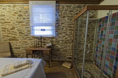 a bedroom with a shower and a bed and a table at Birgi Hotel Saliha Hanim Tas Konak in Birgi