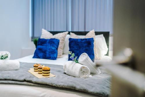 uma cama com uma bandeja de queques e toalhas em Modern 2-bedroom Apt In The Heart Of City Centre em Liverpool