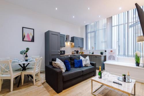 uma sala de estar com um sofá e uma cozinha em Modern 2-bedroom Apt In The Heart Of City Centre em Liverpool