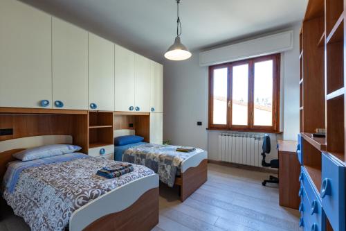 um quarto com 2 camas e uma janela em Accogliente casa a Pontassieve em Pontassieve