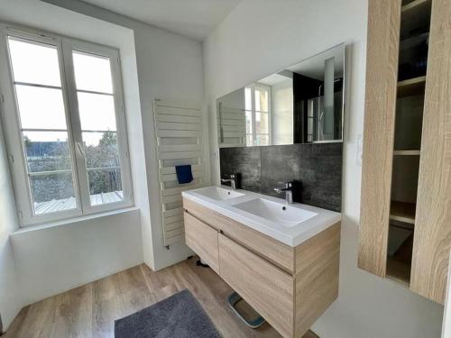 une salle de bain avec un lavabo, une baignoire et un miroir dans l'établissement Charmante maison de 110m2 située à Luc à 800 m de la mer, à Luc-sur-Mer