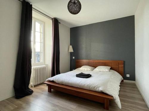 une chambre avec un lit avec une tête de lit en bois et une fenêtre dans l'établissement Charmante maison de 110m2 située à Luc à 800 m de la mer, à Luc-sur-Mer