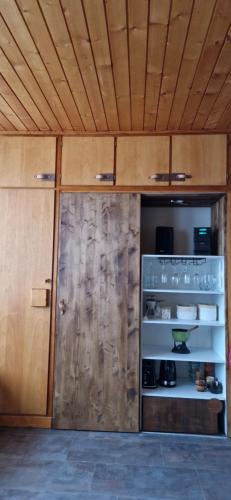 Habitación con puerta de madera y estante con platos. en Studio 2-4 personnes, Le Portillo, proche hypercentre & vieux village, en Val dʼIsère