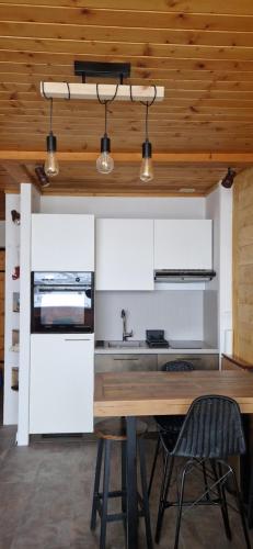 cocina abierta con techo de madera y mesa de madera en Studio 2-4 personnes, Le Portillo, proche hypercentre & vieux village, en Val dʼIsère
